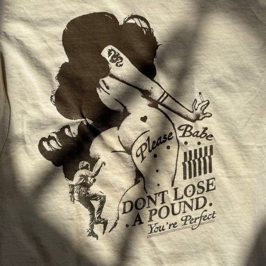 T-shirt with a graphic design of a woman and text on a beige background