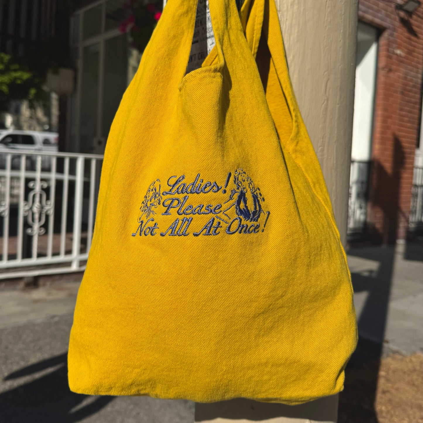 Yellow bag with text hanging on a post outdoors
