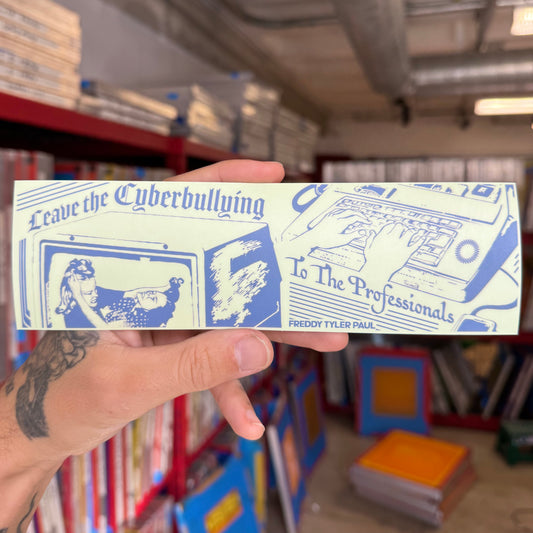 Hand holding a sticker with text and graphics in a library setting