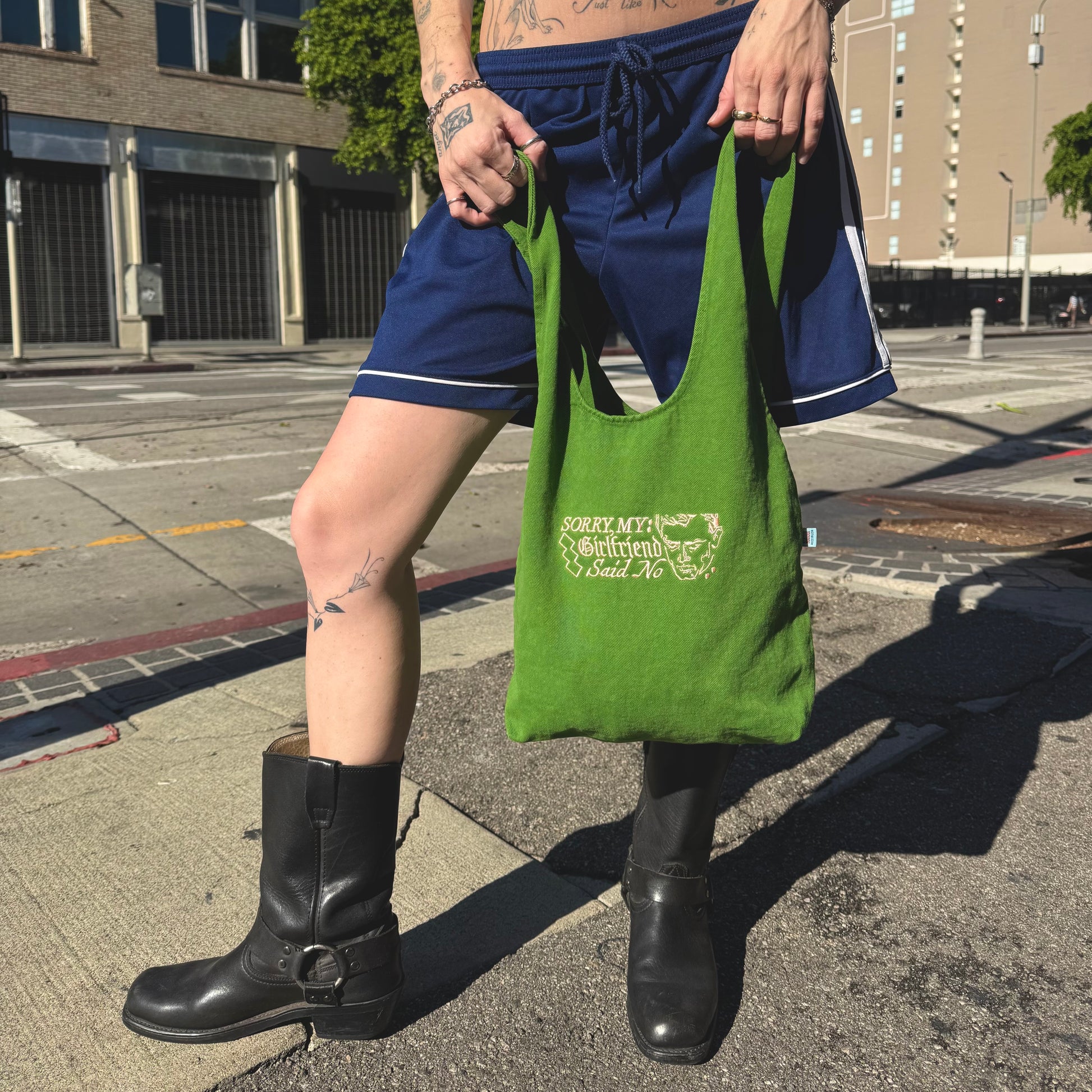 Person holding a green bag on a city street