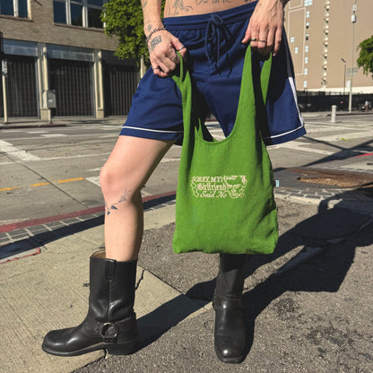 Person holding a green bag on a city street
