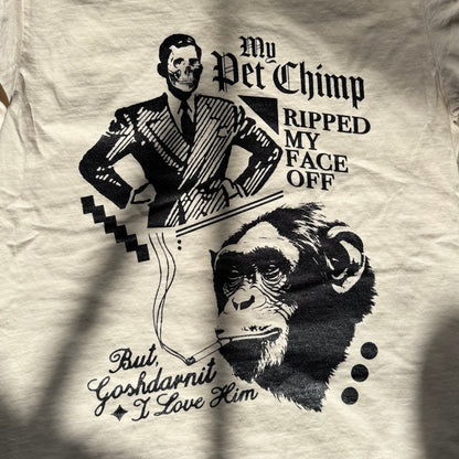 White t-shirt with black graphic design of a man and a chimp, featuring text.