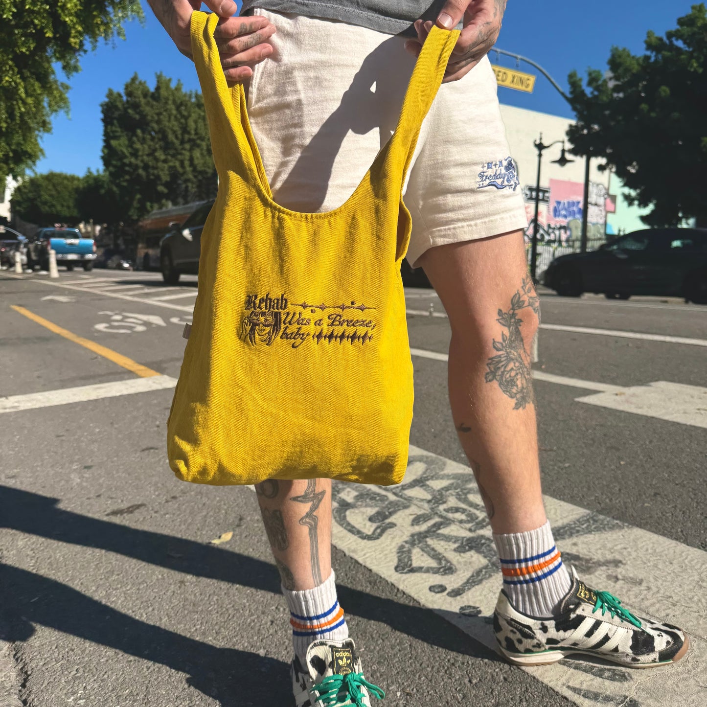 Person holding a yellow bag with text on a street