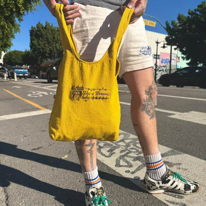 Person holding a yellow bag with text on a street