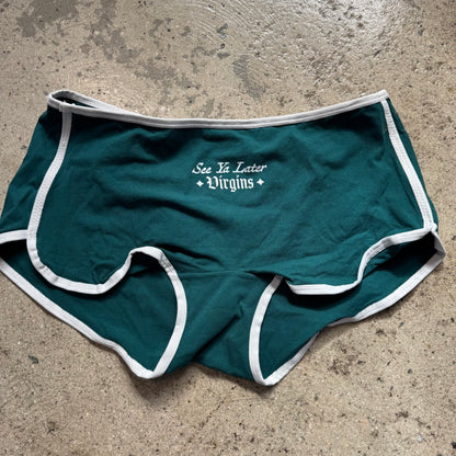 Green underwear with white text on a concrete surface