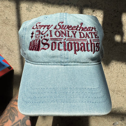 Light blue cap with red text on a concrete surface
