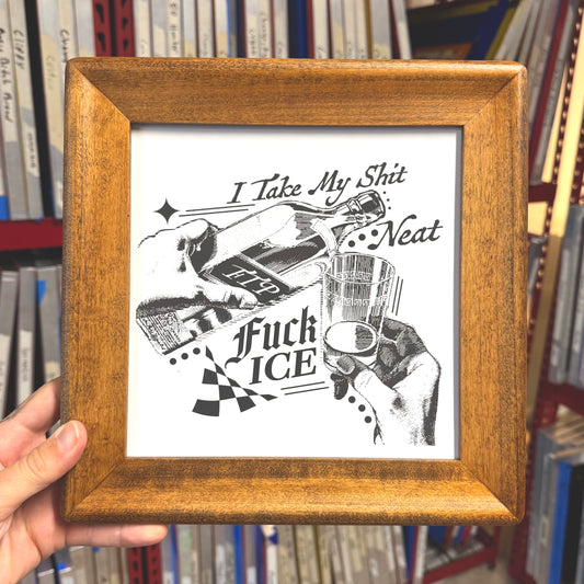Framed artwork with black and white illustration and text held in front of a bookshelf.