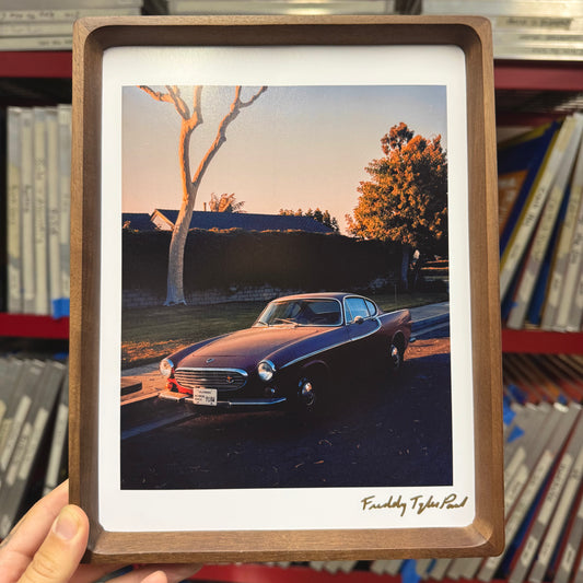 Framed photograph of a vintage car parked in a driveway with a wooden frame.