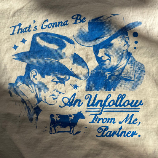 T-shirt with blue cowboy graphics and text on a beige background